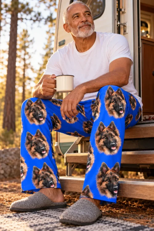 Older man with coffee on camper steps in the pines, in blue pajama pants with German Shepherd faces
