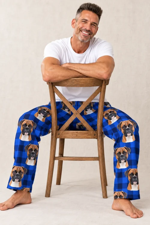 Man sitting backward on a wooden chair in blue plaid mens boxer dog pajamas