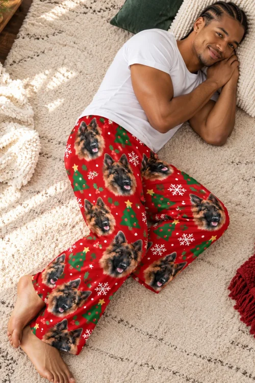 Man lying on a cream rug with his cheek on a pillow in Christmas german shepherd pajama pants