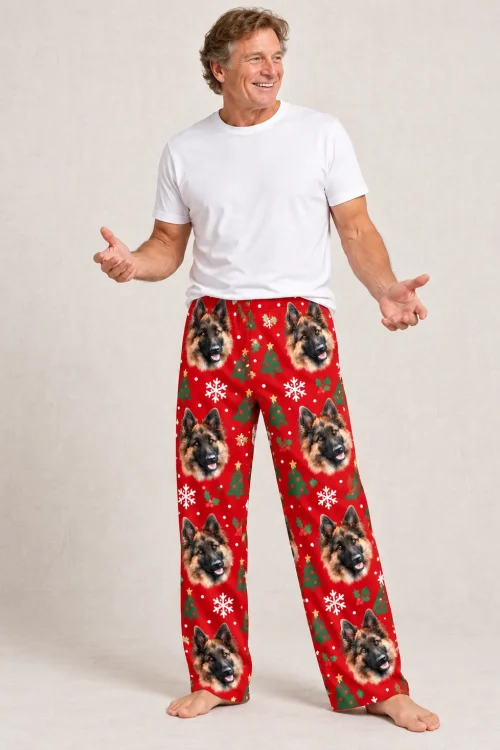 Laughing man with open hands in red Christmas men's german shepherd pajama pants, studio