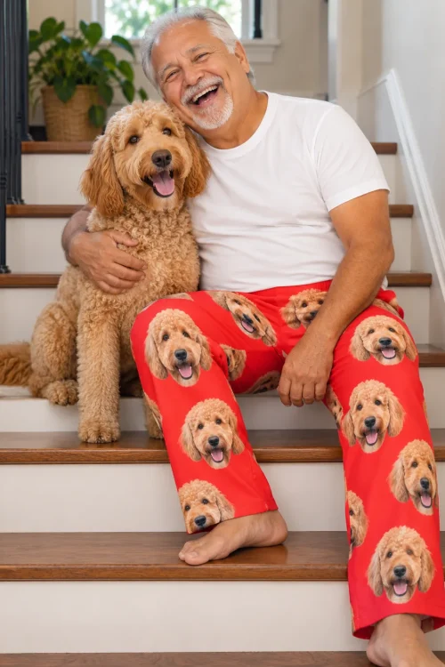 Laughing silver-haired man hugging his goldendoodle on the stairs in red goldendoodle pajama pants