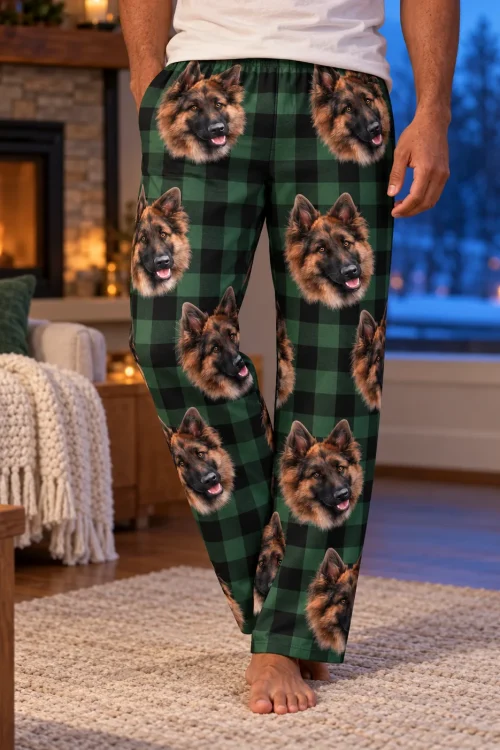 Close view of green plaid pajama pants with German Shepherd faces on a man by a glowing fireplace