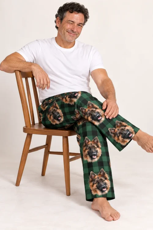 Man winking on a wooden chair in green plaid pajama pants with German Shepherd faces