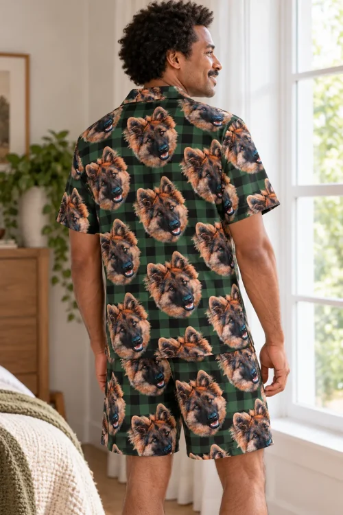 Back view of a man in green and black plaid pajamas with German shepherd faces by a bright window