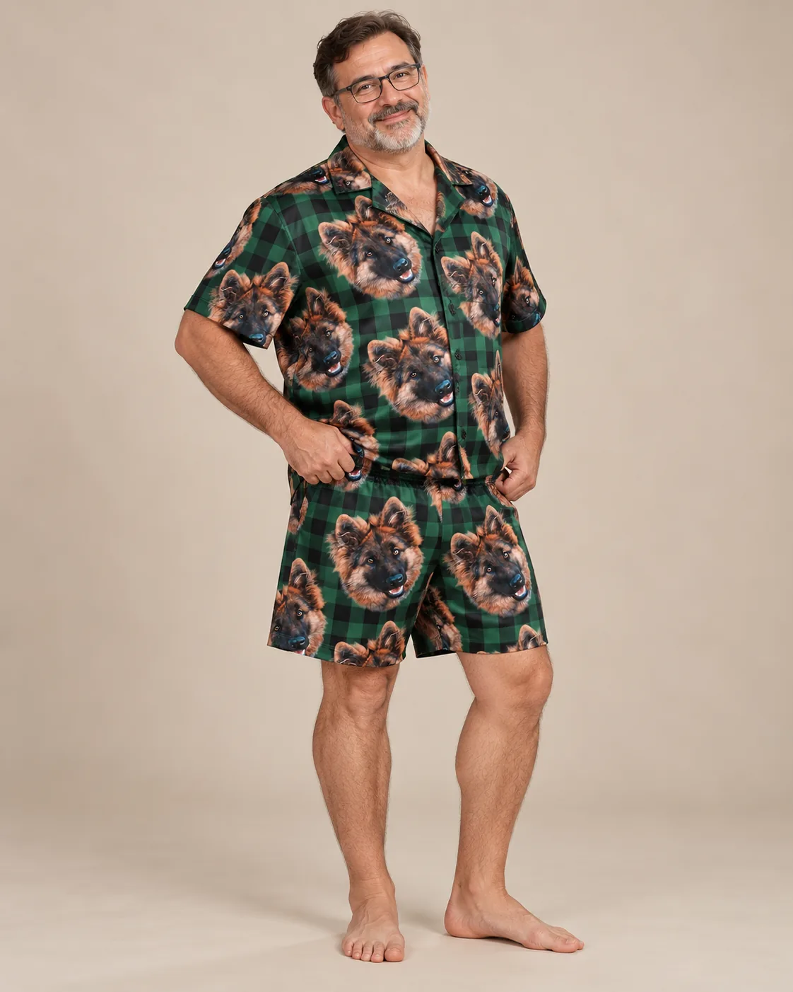 Smiling man in glasses in green plaid pajamas, shirt and shorts covered in German shepherd faces