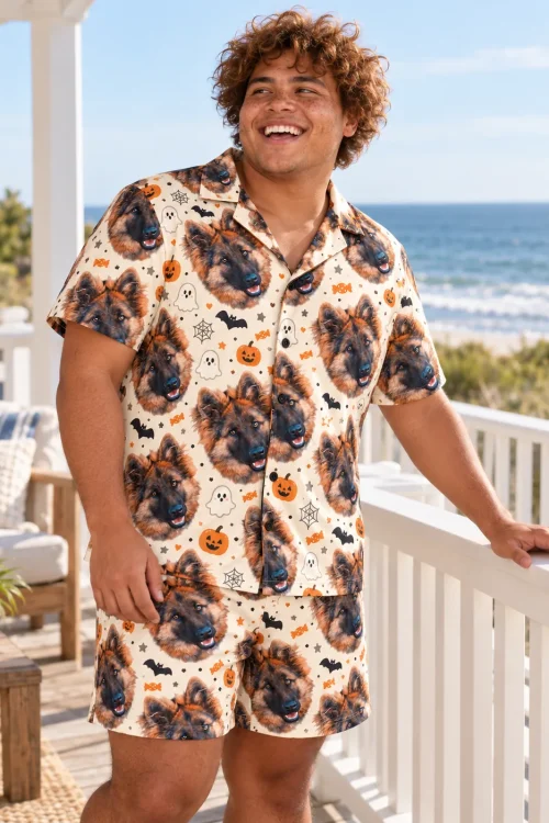 Man laughing on a beach house balcony in cream Halloween pajamas with German shepherd faces and bats