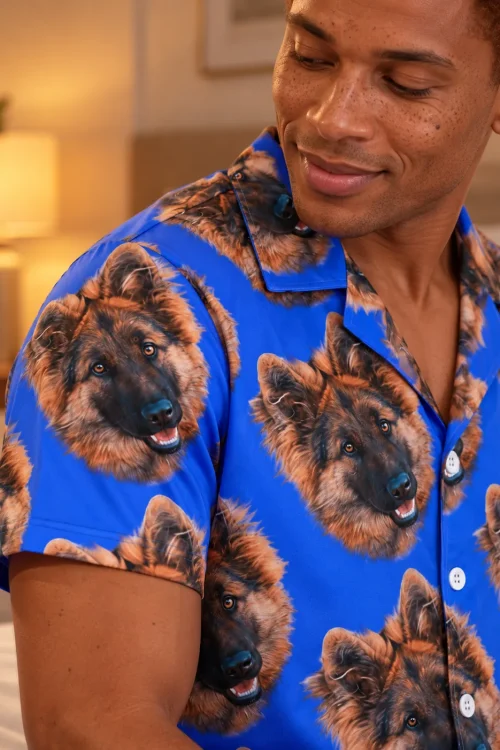 Close-up of a royal blue pajama shirt with German shepherd faces and white buttons on a smiling man