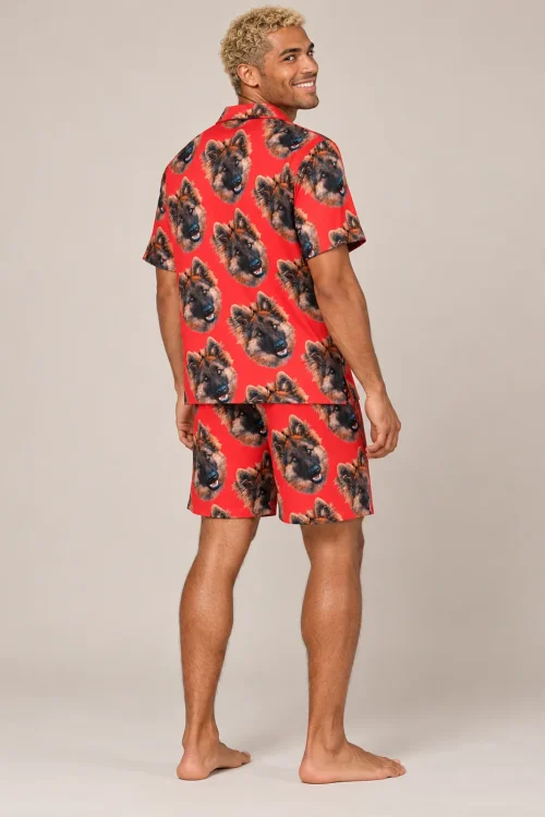 Man looking back over his shoulder in a red pajama set covered in German shepherd faces