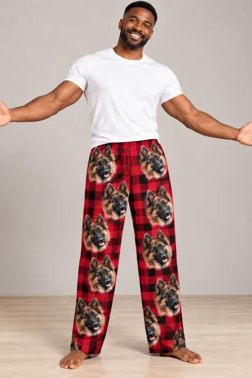 Man with open arms in red plaid pajama pants printed with German Shepherd faces