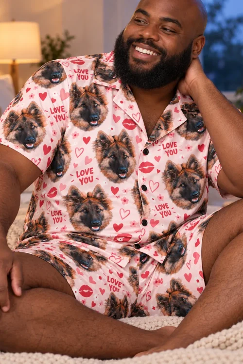 Bearded man relaxing in pale blush Valentines pajamas with German shepherd faces, hearts and lips