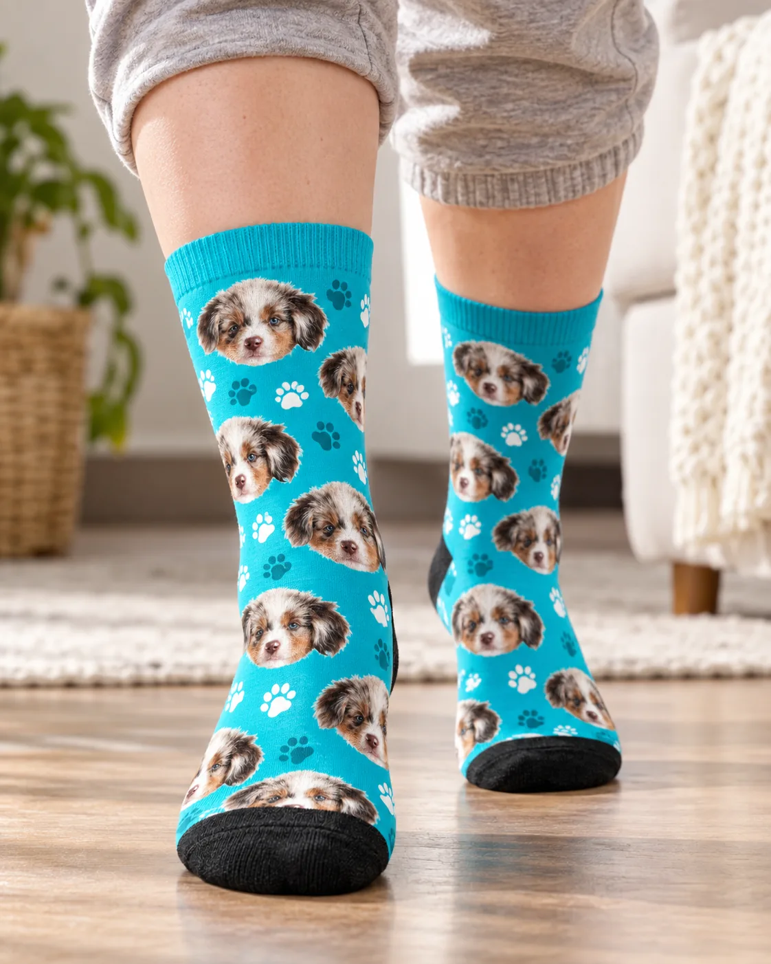 Feet walking across a wood floor in teal paw print socks with puppy faces