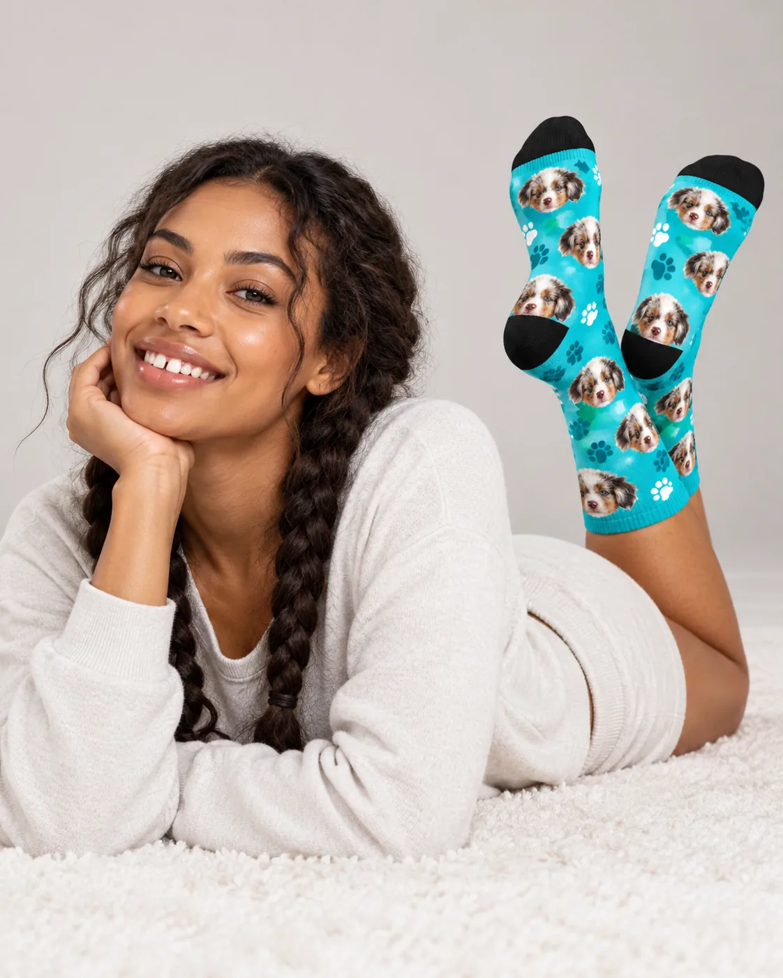 Woman lying on a rug with her feet up in teal paw novelty dog socks with puppy faces