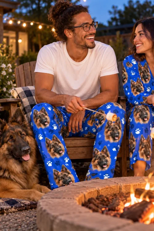Couple roasts marshmallows by a fire pit with their German shepherd in royal blue paws pajama pants