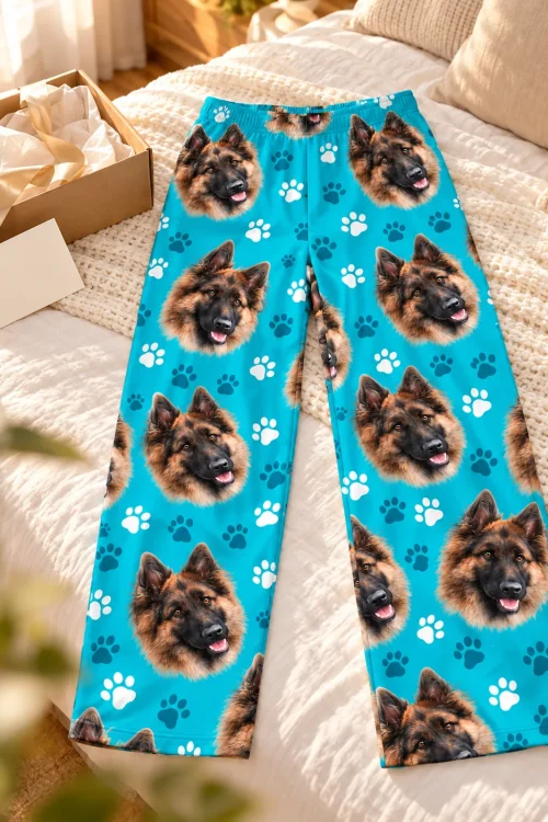 Flat lay of teal paws pajama pants printed with German shepherd faces beside an open gift box