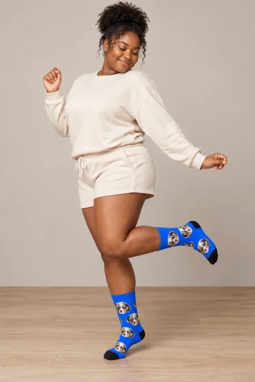 Woman dancing on one foot in royal blue personalized socks with an Aussie puppy face