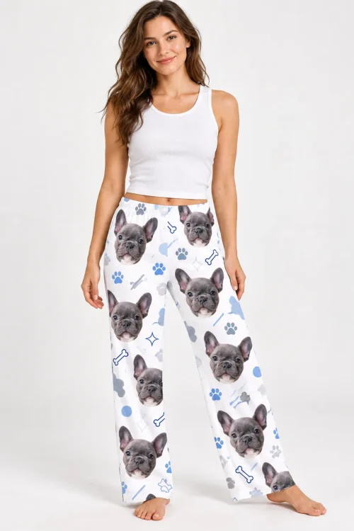 Woman in a white tank top and pet face pajama pants with French bulldog faces and paws