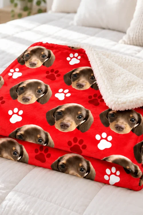 Folded pet face sherpa blanket on a bed with the fluffy sherpa side turned out