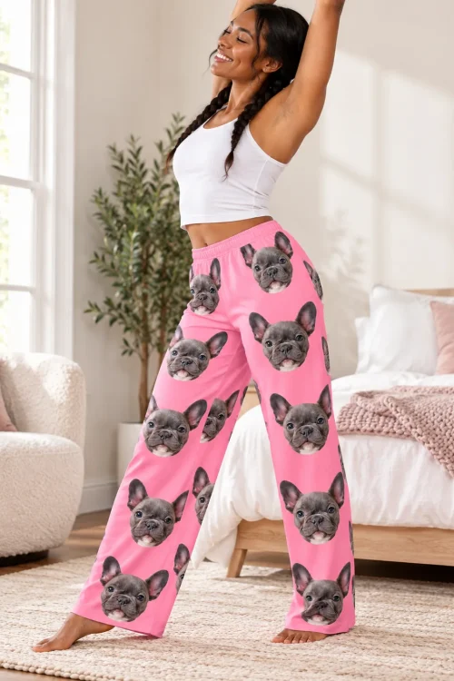 Woman stretching in a bright bedroom in pink pajama pants covered in French bulldog faces