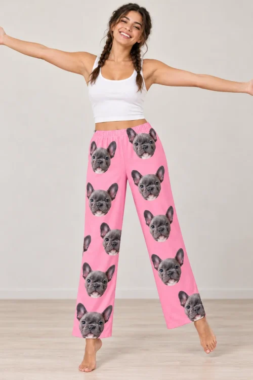 Woman with braids and open arms in bright pink pajama pants printed with French bulldog faces