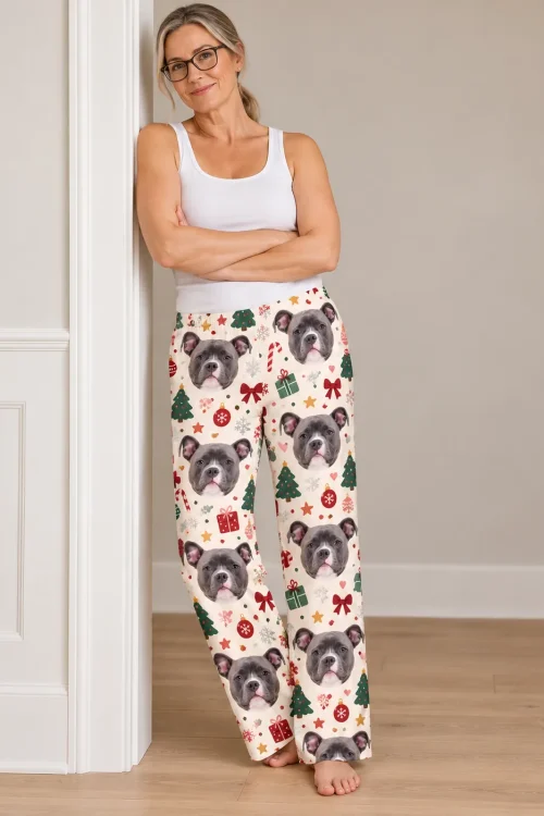 Woman in glasses leaning on a doorframe, arms crossed, in Christmas cream pittie pajamas with trees and bows