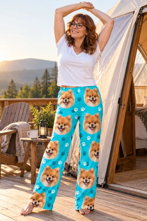 Woman in glasses stretching on a wooden glamping deck at sunrise, in teal paws pomeranian pajama pants