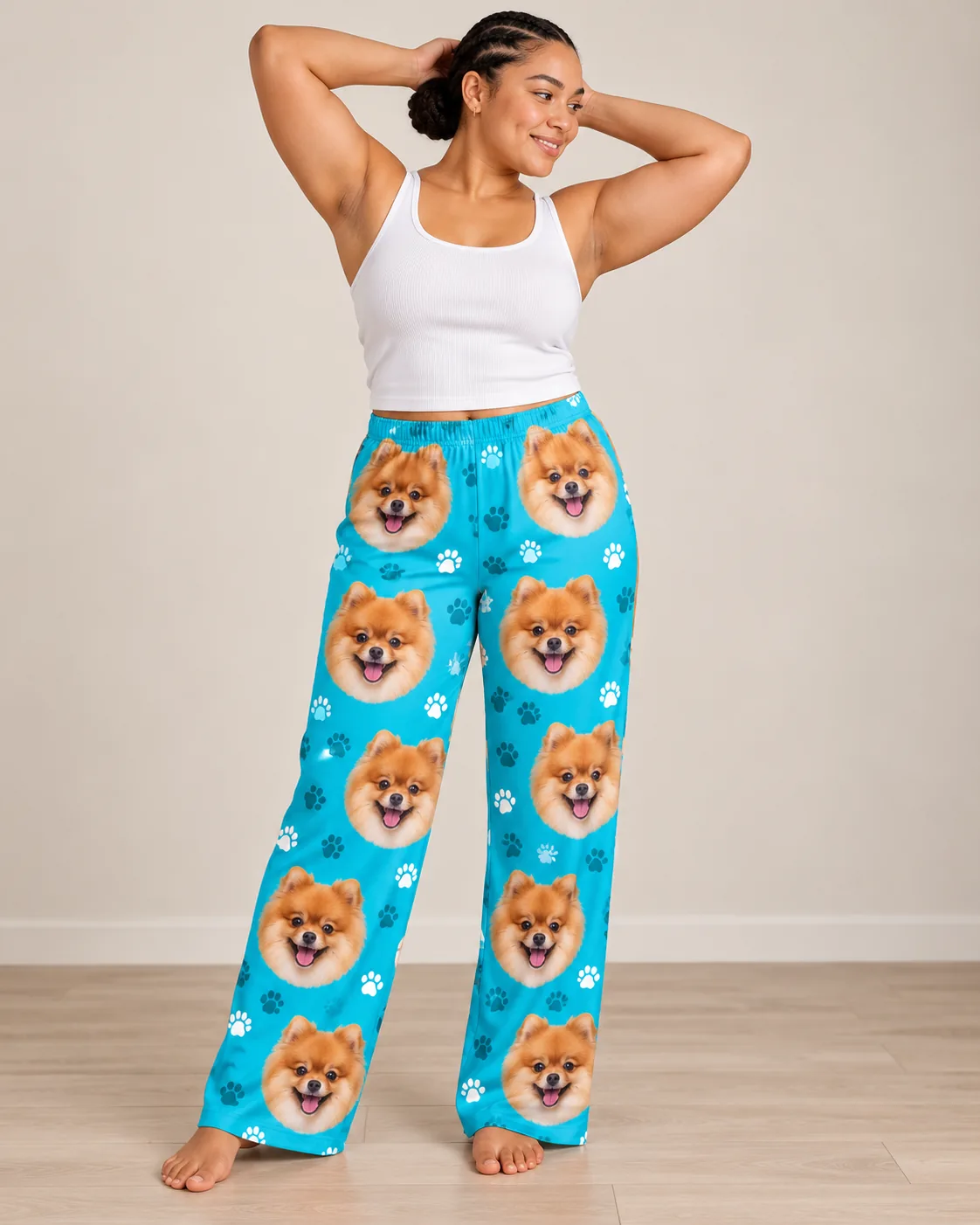 Custom Pomeranian Pajama Pants for Women — teal paws studio | GenzOutfit Woman with braids and hands behind her head, barefoot in teal paws pomeranian pajama pants on a wood floor