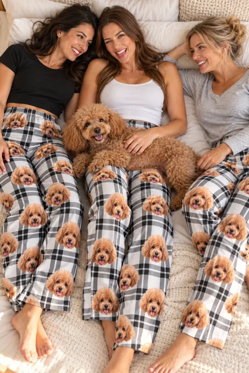 Three friends lying on a bed with an apricot poodle, all in white plaid poodle pajamas
