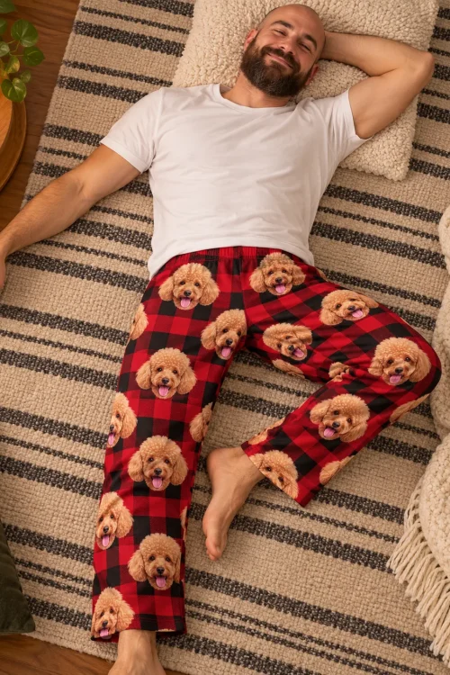 Bearded man lying on a striped rug in red plaid poodle pajama pants