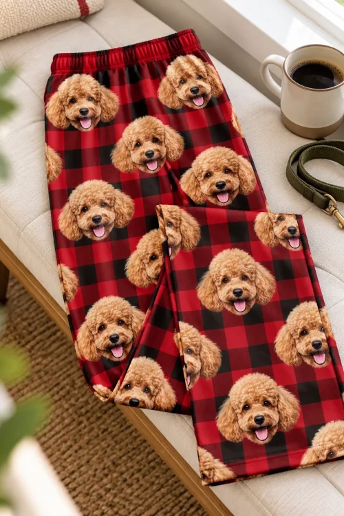 Red plaid poodle PJs folded on a window bench beside a coffee mug and a green leash