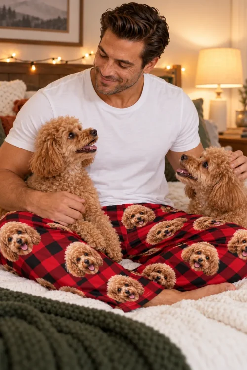 Man on a cozy bed between two apricot poodles, wearing red plaid poodle PJs