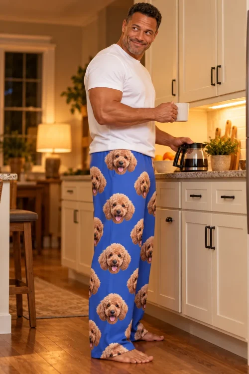 Man pouring coffee in an evening kitchen, in royal blue pajama pants with poodle faces