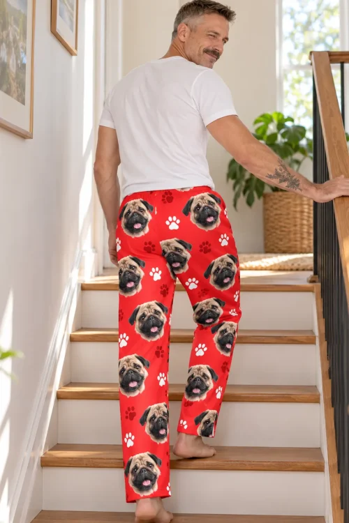 Man climbing wooden stairs, looking back over his shoulder, in red pug pajama pants with paw prints