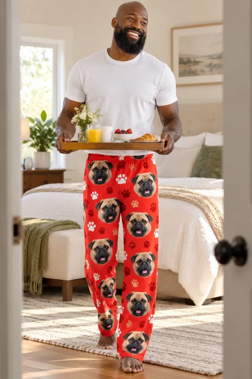 Smiling man carrying a breakfast tray into a sunny bedroom in red paws pug pajama pants
