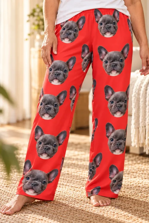 Close view of red pajama pants with French bulldog faces and an elastic waistband on a woman