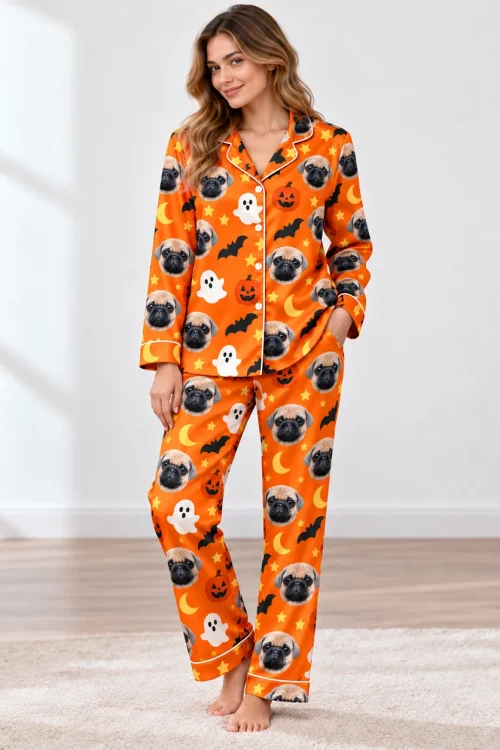 Woman in an orange satin Halloween pajama set with pug faces, ghosts and bats in a bright room