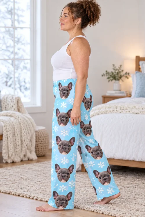 Woman walking through a bright bedroom in light blue snowflake pajama pants with French bulldog faces
