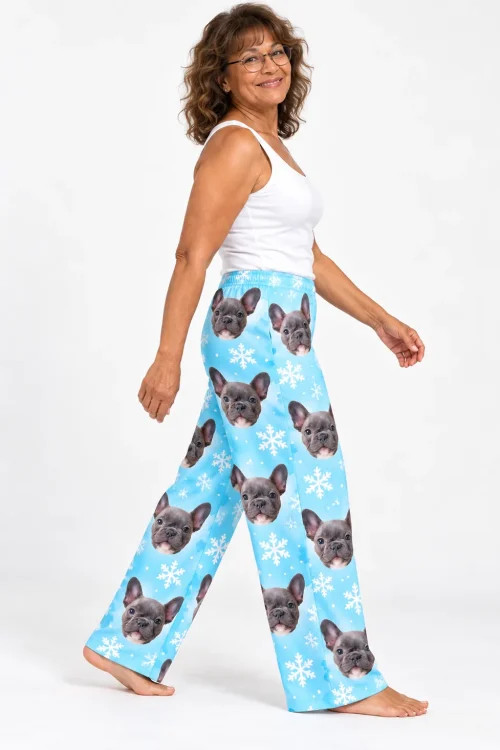 Woman in glasses walking in snowflake pajama pants printed with French bulldog faces
