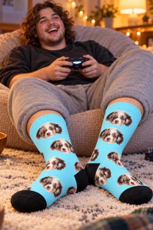 Man gaming on a beanbag wearing light blue socks with his puppy's face