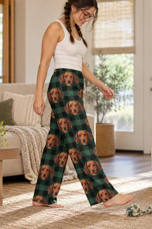 Woman in glasses walking past a rope toy in green plaid women's dachshund pajamas, faces down both legs