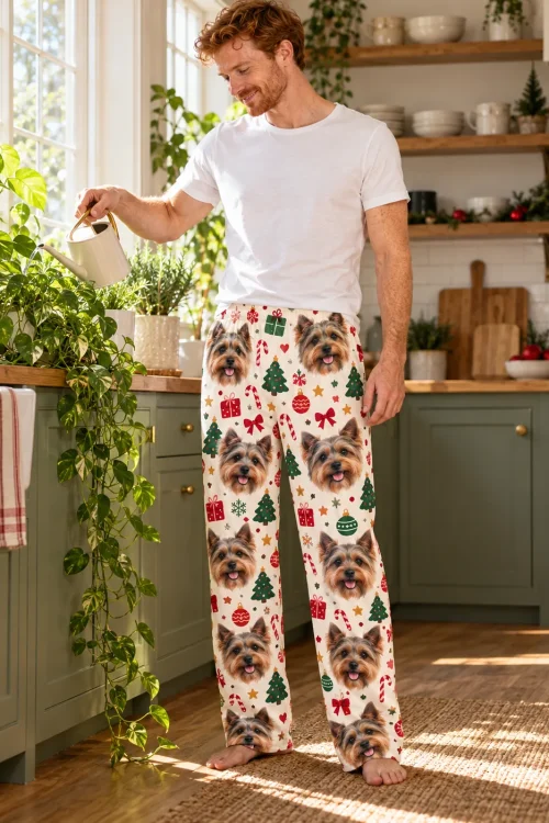 Man watering kitchen plants in cream Christmas Yorkshire terrier pajama pants with Yorkie faces and candy canes