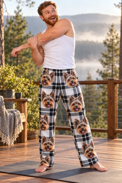 Man stretching on a sunrise deck in white plaid Yorkshire terrier pajama pants, misty pine forest behind